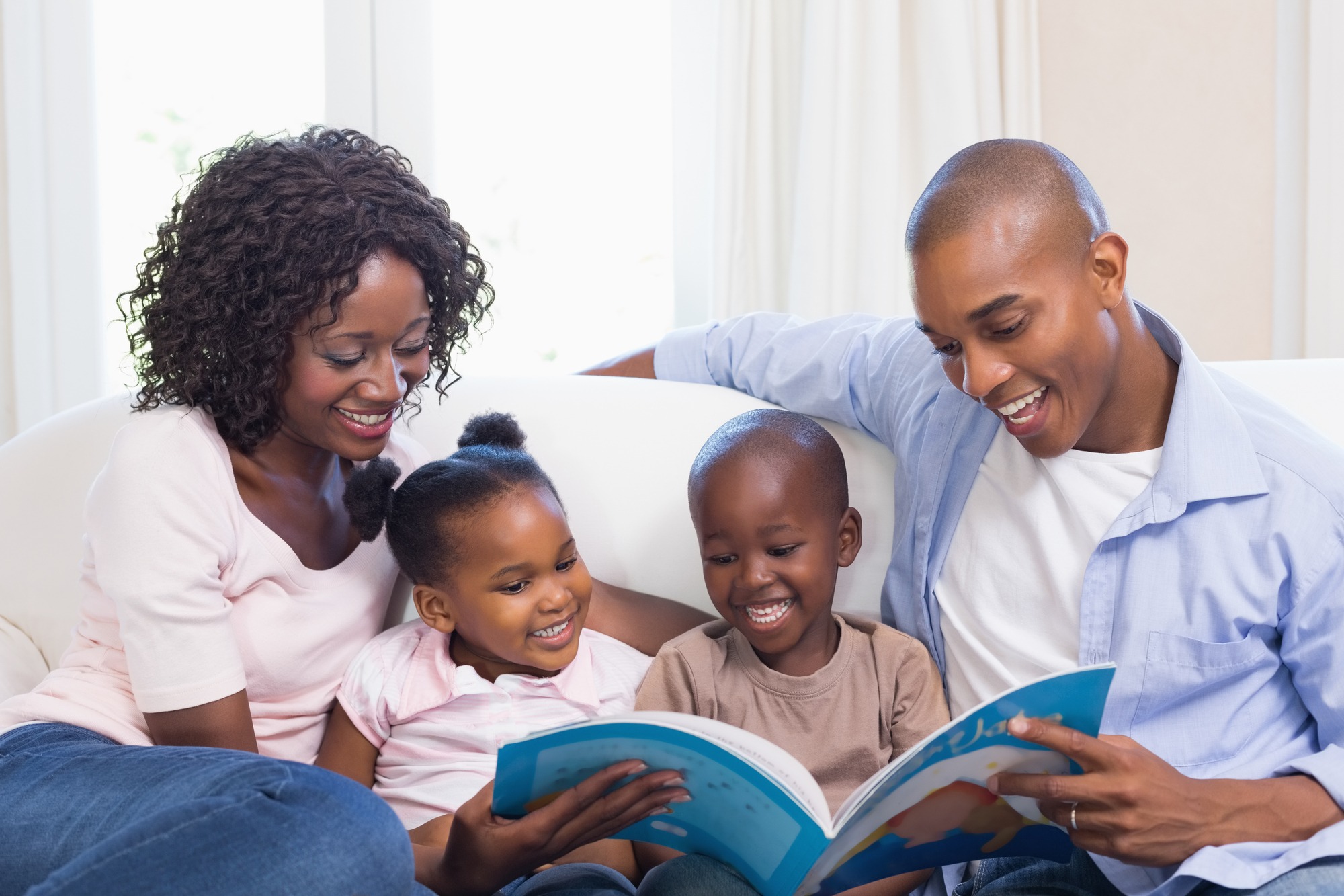 Happy family on the couch reading storybook at home